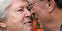 Foto af Conny og Svend Kramer der kigger kærligt på hinanden. Svend har Alzheimers Sygdom, og jeg har interviewet parret to gange i forbindelse med en kampagne for Alzheimerforeningen. 